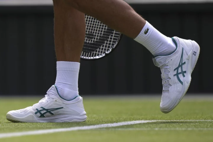 Novak Djokovic plays at Wimbledon with the number '23' printed on his white tennis shoes